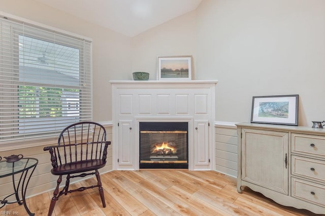 633 Aguila Dr, Chesapeake, VA 23322 - living area with lofted ceiling, a glass covered fireplace, light wood-style flooring, and a wainscoted wall