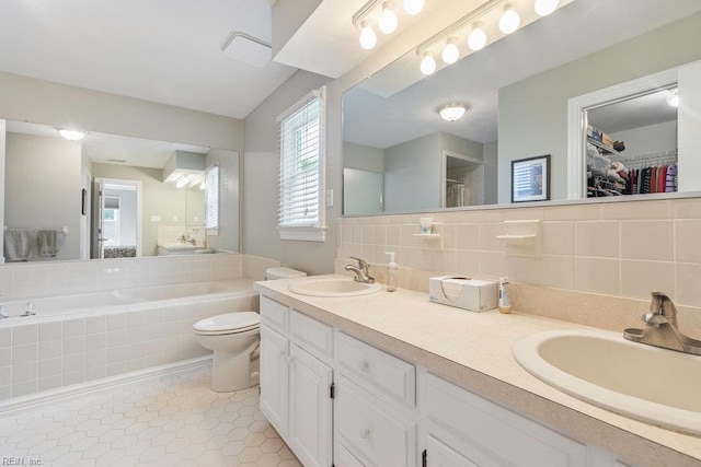 633 Aguila Dr, Chesapeake, VA 23322 - bathroom featuring a bath, double vanity, backsplash, tile patterned floors, and a spacious closet