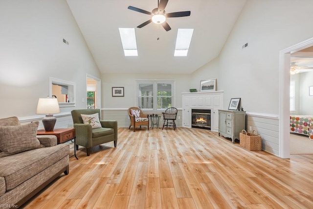 633 Aguila Dr, Chesapeake, VA 23322 - living room featuring high vaulted ceiling, ceiling fan, light wood finished floors, a glass covered fireplace, and wainscoting