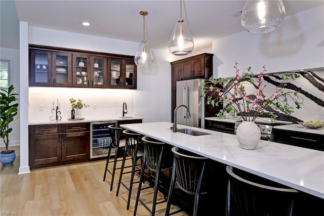 3 Menife Ct, Williamsburg, VA 23188 - indoor wet bar featuring beverage cooler, appliances with stainless steel finishes, tasteful backsplash, light wood-style flooring, and pendant lighting