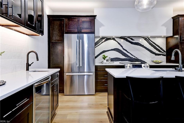 3 Menife Ct, Williamsburg, VA 23188 - kitchen featuring freestanding refrigerator, wine cooler, decorative backsplash, light countertops, and light wood-style flooring