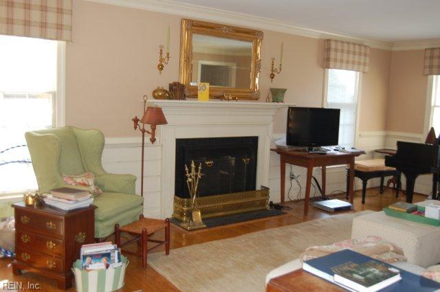 110 Thomas Gates, Williamsburg, VA 23185 - living room with crown molding, wood finished floors, a fireplace, and a wainscoted wall
