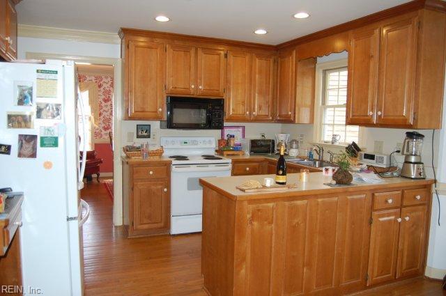 110 Thomas Gates, Williamsburg, VA 23185 - kitchen featuring white appliances, wood finished floors, a peninsula, light countertops, and brown cabinets