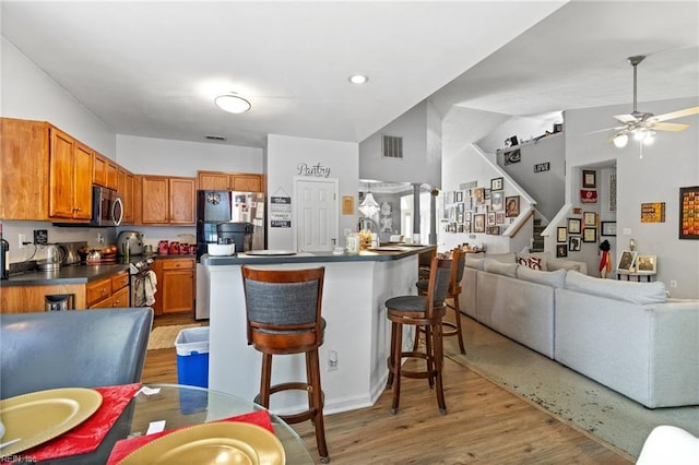 1058 Hillpoint Rd, Suffolk, VA 23434 - kitchen featuring stainless steel appliances, dark countertops, brown cabinets, and ceiling fan