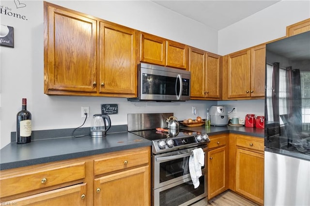 1058 Hillpoint Rd, Suffolk, VA 23434 - kitchen featuring appliances with stainless steel finishes, dark countertops, and brown cabinetry
