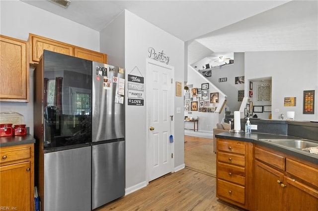 1058 Hillpoint Rd, Suffolk, VA 23434 - kitchen featuring freestanding refrigerator, dark countertops, light wood-type flooring, and brown cabinets