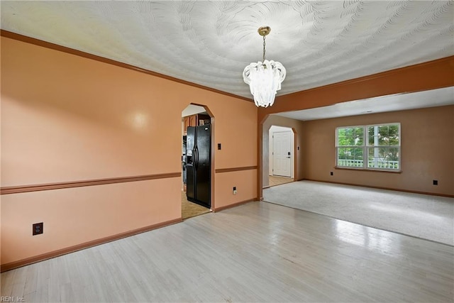 700 Hilltop Ct, Chesapeake, VA 23322 - spare room featuring arched walkways, a chandelier, and wood finished floors