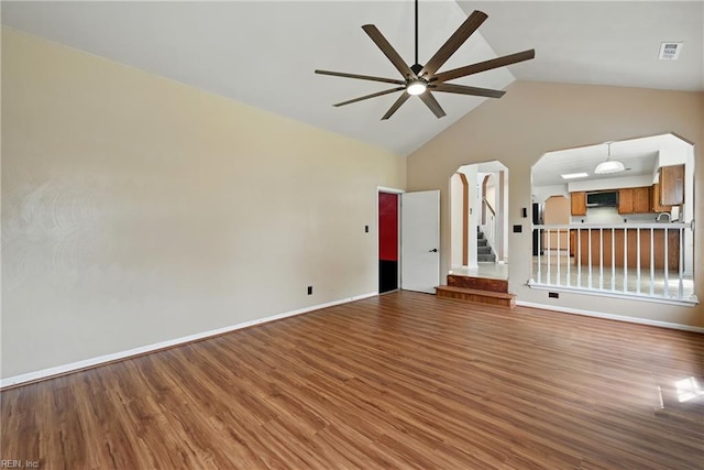700 Hilltop Ct, Chesapeake, VA 23322 - unfurnished living room with ceiling fan, wood finished floors, stairway, high vaulted ceiling, and arched walkways
