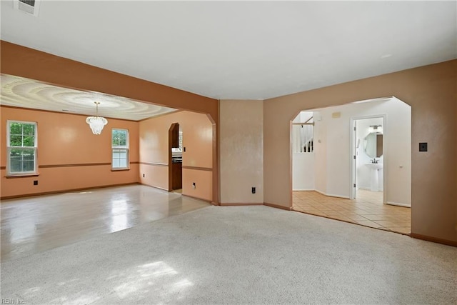 700 Hilltop Ct, Chesapeake, VA 23322 - carpeted empty room featuring arched walkways and a chandelier