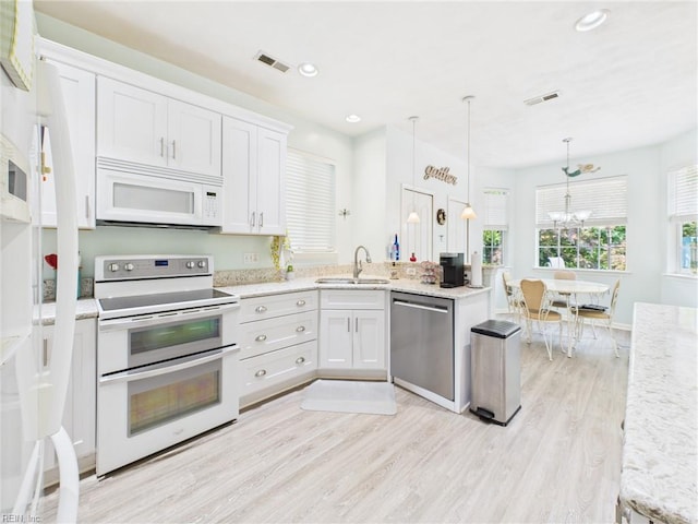 2909 Drum Point Cres, Chesapeake, VA 23321 - kitchen with white appliances, white cabinets, light wood-style floors, decorative light fixtures, and a chandelier