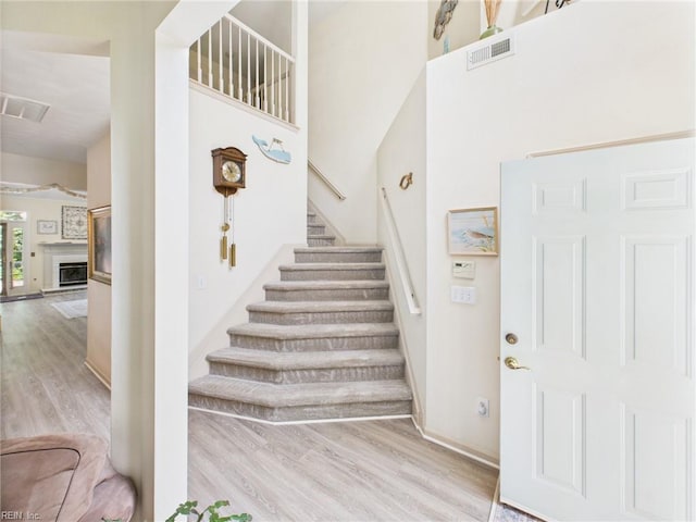 2909 Drum Point Cres, Chesapeake, VA 23321 - stairway featuring wood finished floors, a high ceiling, and a glass covered fireplace