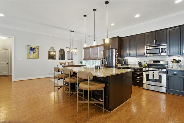 3216 Meanley Dr, Chesapeake, VA 23323 - kitchen with appliances with stainless steel finishes, a kitchen breakfast bar, decorative backsplash, crown molding, and light wood-style flooring