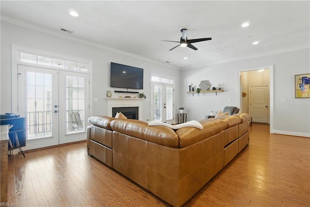3216 Meanley Dr, Chesapeake, VA 23323 - living area featuring french doors, crown molding, light wood-style floors, ceiling fan, and a fireplace