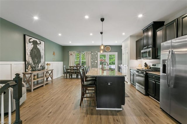 112 Mccormick Pl, Williamsburg, VA 23185 - kitchen featuring appliances with stainless steel finishes, light stone countertops, dark cabinetry, a kitchen breakfast bar, and recessed lighting
