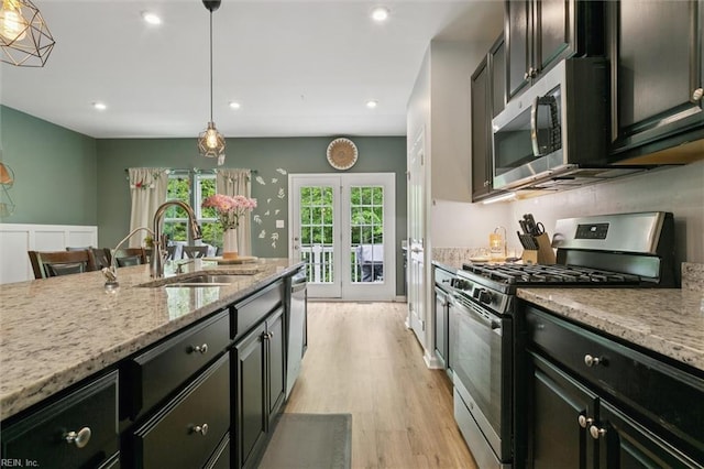 112 Mccormick Pl, Williamsburg, VA 23185 - kitchen with stainless steel appliances, light wood-style floors, light stone counters, french doors, and hanging light fixtures