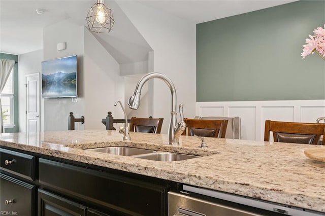 112 Mccormick Pl, Williamsburg, VA 23185 - kitchen featuring dishwasher, light stone counters, dark cabinetry, decorative light fixtures, and a decorative wall