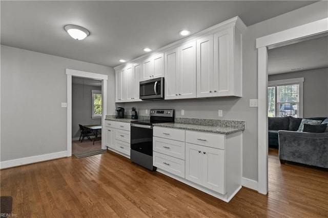 2309 Drum Creek Rd, Chesapeake, VA 23321 - kitchen with stainless steel appliances, dark wood-type flooring, white cabinetry, light stone countertops, and recessed lighting