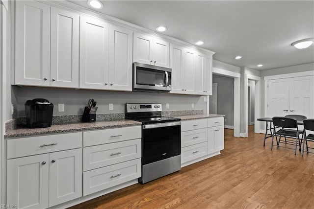 2309 Drum Creek Rd, Chesapeake, VA 23321 - kitchen featuring appliances with stainless steel finishes, white cabinets, light wood-type flooring, recessed lighting, and light stone countertops