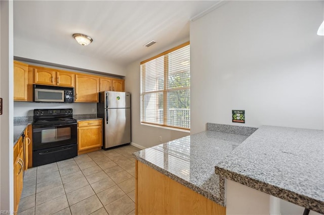249 W Freemason St Unit 408, Norfolk, VA 23510 - kitchen featuring black appliances, light tile patterned floors, light stone counters, and a peninsula