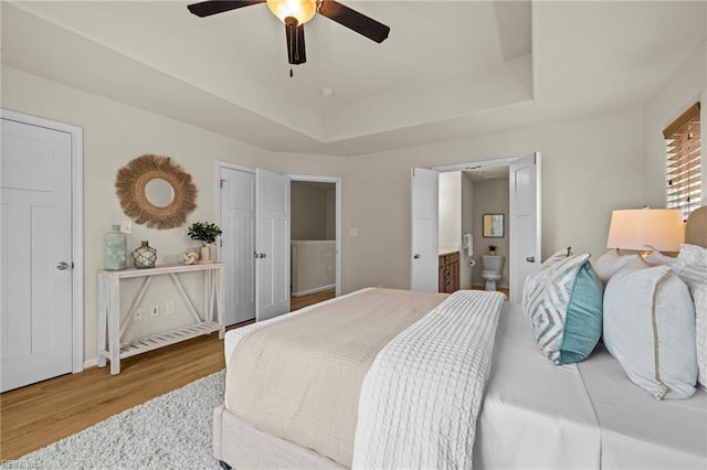 616 Foster Ln, Virginia Beach, VA 23451 - bedroom featuring wood finished floors, a tray ceiling, connected bathroom, and a ceiling fan