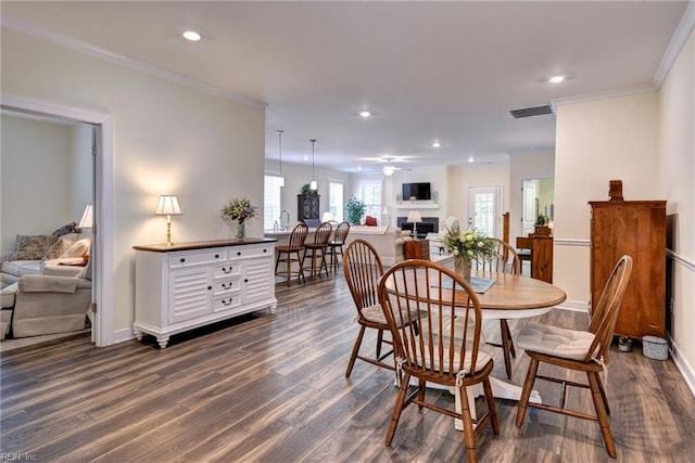 3998 Isaac Cir, Williamsburg, VA 23188 - dining space featuring dark wood-style flooring, recessed lighting, a ceiling fan, ornamental molding, and a fireplace