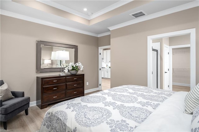 105 Repose Rd, Williamsburg, VA 23185 - bedroom with light wood finished floors, ornamental molding, recessed lighting, a tray ceiling, and a walk in closet