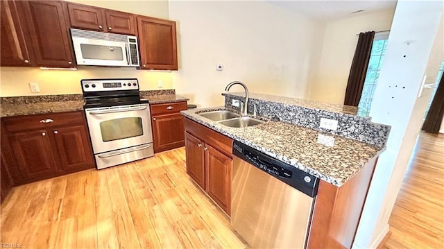 450 W Princess Anne Rd Unit 208, Norfolk, VA 23517 - kitchen with stainless steel appliances, light wood-style floors, dark stone counters, and an island with sink