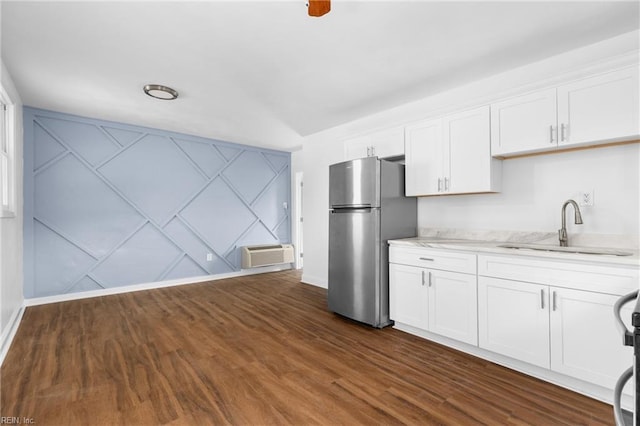 2850 Grandy Ave, Norfolk, VA 23509 - kitchen with freestanding refrigerator, white cabinets, dark wood-type flooring, a wall unit AC, and a decorative wall