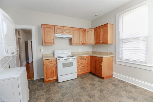 1439 Moultrie Ave, Norfolk, VA 23509 - kitchen featuring white electric stove, under cabinet range hood, stacked washer / drying machine, light countertops, and stone finish flooring