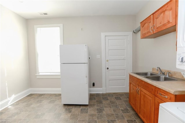 1439 Moultrie Ave, Norfolk, VA 23509 - kitchen featuring freestanding refrigerator, light countertops, and brown cabinetry
