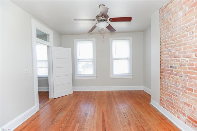 1439 Moultrie Ave, Norfolk, VA 23509 - empty room featuring light wood-type flooring, a ceiling fan, and brick wall