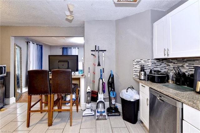 387 Sampson Ave, Hampton, VA 23661 - kitchen with stainless steel dishwasher, white cabinets, backsplash, light stone countertops, and a textured ceiling