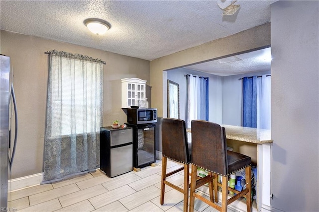 387 Sampson Ave, Hampton, VA 23661 - dining room featuring healthy amount of natural light, a textured ceiling, and beverage cooler