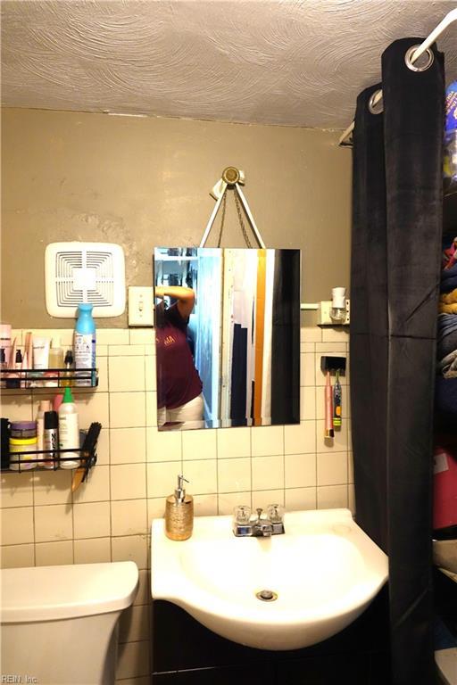 806 Lee St, West Point, VA 23181 - bathroom featuring tile walls, vanity, and backsplash