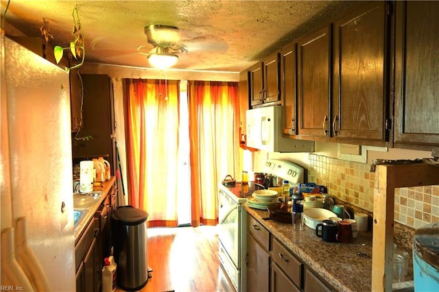 806 Lee St, West Point, VA 23181 - kitchen with white appliances, decorative backsplash, light wood-style flooring, and dark brown cabinets