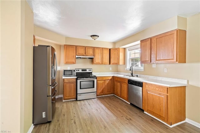 1118 35th St, Newport News, VA 23607 - kitchen featuring appliances with stainless steel finishes, under cabinet range hood, light wood finished floors, light countertops, and brown cabinetry