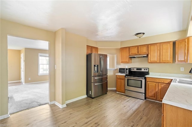 1118 35th St, Newport News, VA 23607 - kitchen featuring stainless steel appliances, under cabinet range hood, light countertops, light wood-style floors, and brown cabinetry