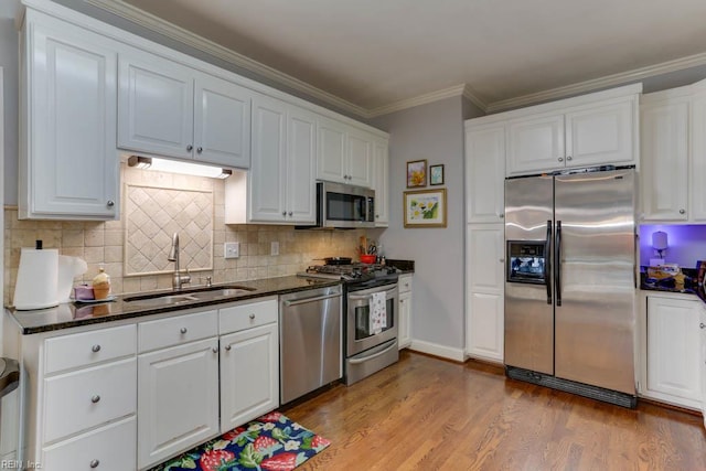 1208 Smith Cove Cir, Virginia Beach, VA 23455 - kitchen featuring appliances with stainless steel finishes, white cabinetry, wood finished floors, dark stone countertops, and ornamental molding