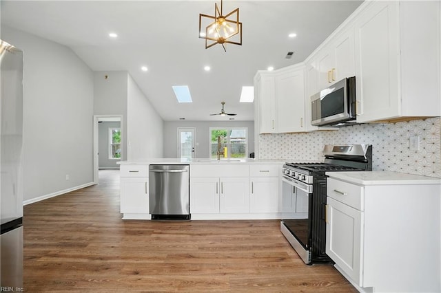 2317 Esplanade Dr, Virginia Beach, VA 23456 - kitchen with appliances with stainless steel finishes, a peninsula, white cabinetry, tasteful backsplash, and light countertops