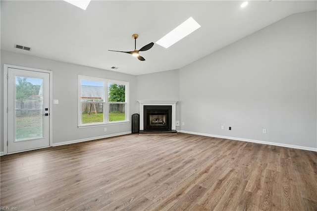 2317 Esplanade Dr, Virginia Beach, VA 23456 - unfurnished living room featuring a skylight, vaulted ceiling, wood finished floors, a ceiling fan, and a fireplace with raised hearth