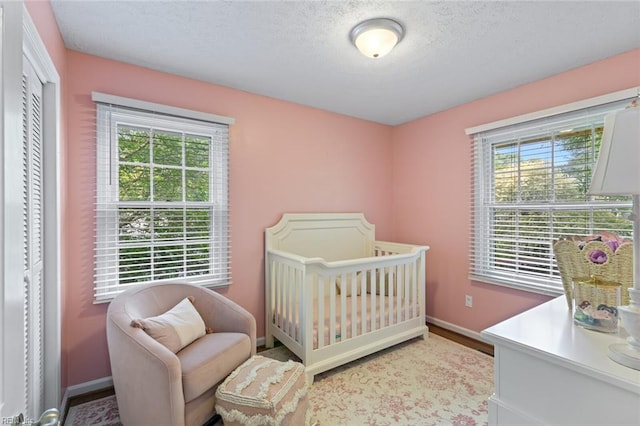 102 Dogwood Dr, Williamsburg, VA 23185 - bedroom featuring a textured ceiling, a crib, and wood finished floors