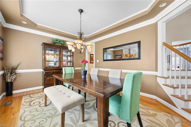 2224 Cabot Ct, Virginia Beach, VA 23456 - dining room featuring light wood finished floors, a chandelier, stairway, a raised ceiling, and crown molding