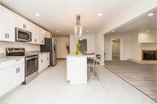 3760 Nansemond Pkwy, Suffolk, VA 23435 - kitchen with stainless steel appliances, a kitchen breakfast bar, white cabinetry, a kitchen island, and recessed lighting