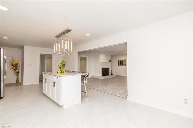 3760 Nansemond Pkwy, Suffolk, VA 23435 - kitchen featuring a breakfast bar, white cabinetry, freestanding refrigerator, open floor plan, and hanging light fixtures