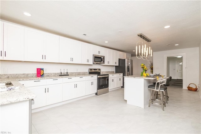 3760 Nansemond Pkwy, Suffolk, VA 23435 - kitchen with stainless steel appliances, recessed lighting, white cabinets, a breakfast bar area, and pendant lighting
