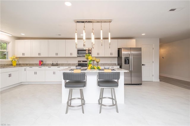 3760 Nansemond Pkwy, Suffolk, VA 23435 - kitchen with appliances with stainless steel finishes, a kitchen island, white cabinets, a breakfast bar, and recessed lighting