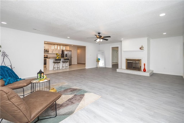3760 Nansemond Pkwy, Suffolk, VA 23435 - living room with a textured ceiling, recessed lighting, light wood-type flooring, a ceiling fan, and a fireplace