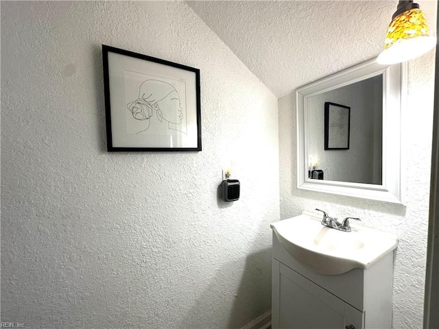 154 Tynes St, Suffolk, VA 23434 - bathroom with vanity, lofted ceiling, a textured wall, and a textured ceiling