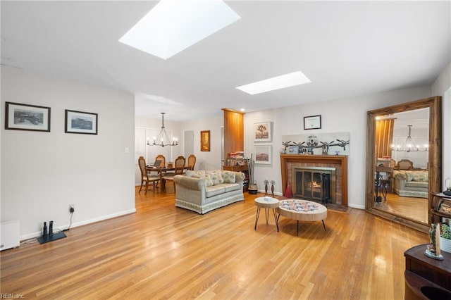 701 Milton Dr, Hampton, VA 23666 - living room with a skylight, a chandelier, light wood finished floors, and a brick fireplace