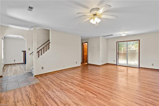 128 Glen Echo Dr, Norfolk, VA 23505 - unfurnished living room with ceiling fan, light wood-style flooring, arched walkways, and stairs